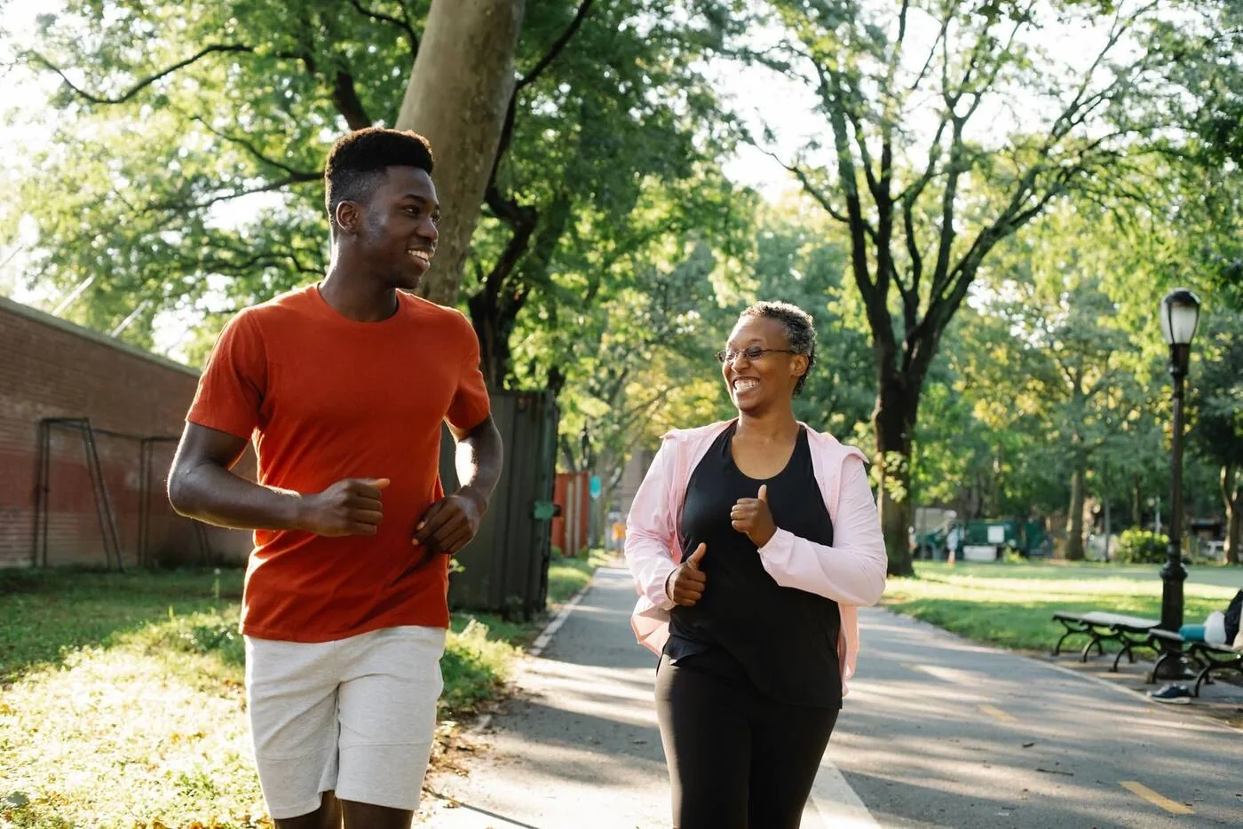 Zwei Menschen joggen im Park – Symbolbild für Beweglichkeit und Wohlbefinden